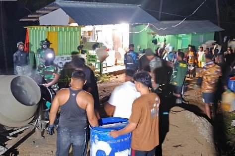 Suasana gotong royong malam hari di Desa Tonala, warga dan prajurit TNI bahu membahu menyelesaikan rabat beton dalam program TMMD ke-126.(Foto : Dok. Ist.)